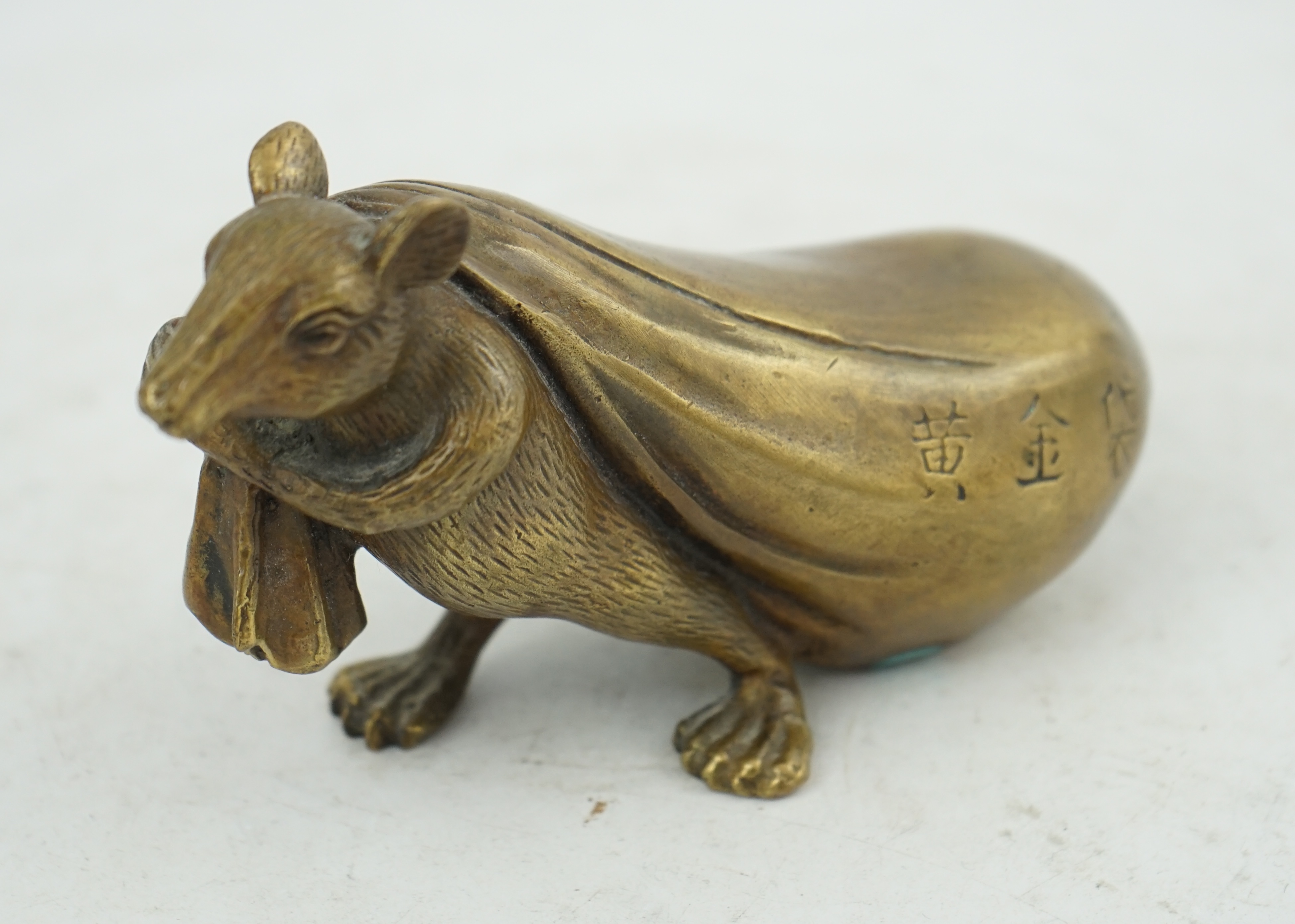 A Chinese bronze rat carrying a sack, signed in casting, 14cm long. Condition - fair